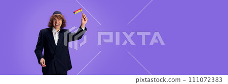 Jewish man with grogger posing against purple against purple studio background with negative space to insert text. Ad Jewish man with grogger posing against purple against purple studio background with negative space to insert text. Ad 111072383