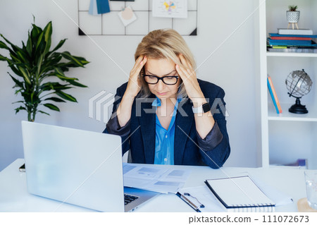 Shocked 50's mature businesswoman, middle-aged experienced female looking at documents in office. Accounting report. Frustrated worried face expression emotion feelings problem perception reaction. 111072673