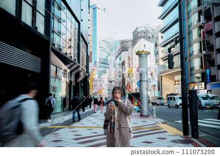 Young woman in winter clothes looking at smartphone Young woman in winter clothes looking at smartphone 111073200