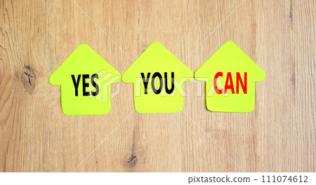 Motivational and Yes you can symbol. Concept words Yes you can on beautiful yellow paper houses. Beautiful wooden table wooden background. Business motivational and Yes you can concept. Copy space. Motivational and Yes you can symbol. Concept words Yes you can on beautiful yellow paper houses. Beautiful wooden table wooden background. Business motivational and Yes you can concept. Copy space. 111074612
