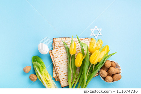 Passover Greeting Card with Matzah, Waluts and Yellow Tulip Flowers on Blue Background. 111074730