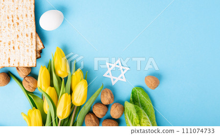Passover Greeting Card with Matzah, Waluts and Yellow Tulip Flowers on Blue Background. 111074733