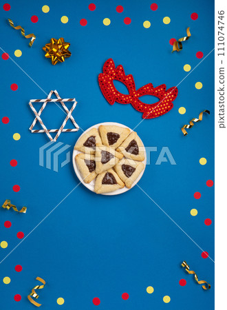 Hamantaschen Cookies, Carnival Mask, Noisemaker on Blue Background. Purim Celebration, Jewish Carnival Holiday Concept. Hamantaschen Cookies, Carnival Mask, Noisemaker on Blue Background. Purim Celebration, Jewish Carnival Holiday Concept. 111074746