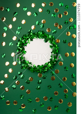 St. Patrick's Day Leprechaun Hat, Gold Coins, Shamrocks and Party Favors on Green Background. St. Patrick's Day Leprechaun Hat, Gold Coins, Shamrocks and Party Favors on Green Background. 111074759