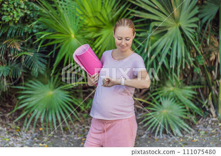 Energetic pregnant woman takes her workout outdoors, using an exercise mat for a refreshing and health-conscious outdoor exercise session 111075480