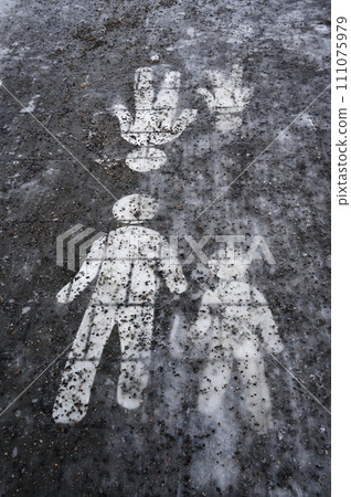 Ice covered sidewalk with a pedestrian path sign 111075979