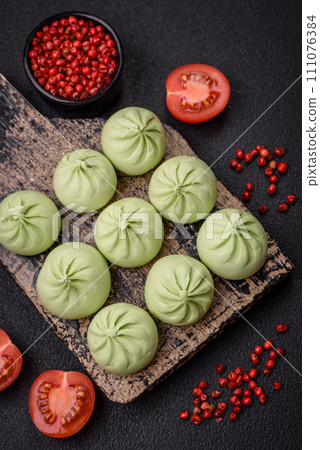 Raw khinkali or green dumplings with salt, spices and herbs 111076384