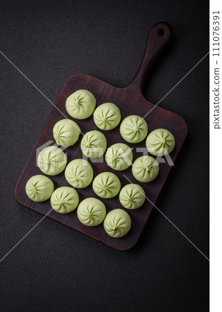 Raw khinkali or green dumplings with salt, spices and herbs 111076391