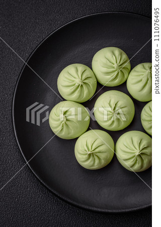 Raw khinkali or green dumplings with salt, spices and herbs 111076495