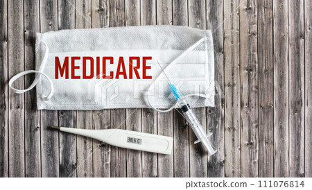 Medical mask with the text MEDICAL CARE on a wooden background. Medical concept. Medical mask with the text MEDICAL CARE on a wooden background. Medical concept. 111076814