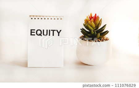 capital text written on a notepad with a flower on a white background capital text written on a notepad with a flower on a white background 111076829