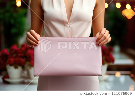 Pink clutch, women's bag in the hands of a woman 111076909