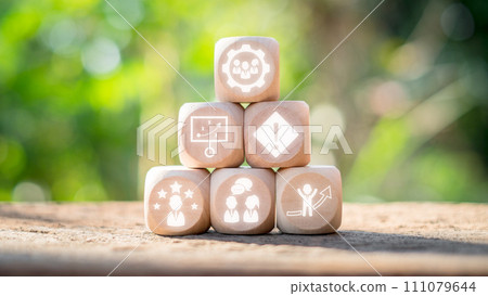 Team building concept, Wooden block on desk with team building icon on virtual screen. Team Spirit, Motivation, Training, Competency, Collaboration, Communication, Goal, Social Relations. 111079644