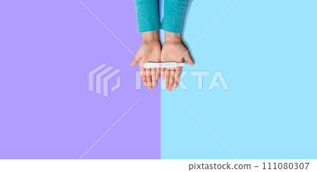 Woman holding a positive pregnancy test 111080307