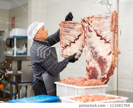 Butcher preparing raw veal ribs for sale in butchery 111081769