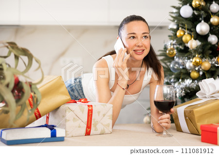 woman is relaxing at home with glass of wine during New Year holidays 111081912