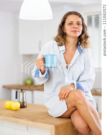 Portrait of smiling girl sitting on table 111082072