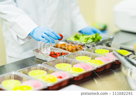 A woman at a food factory making lunch boxes, faceless A woman at a food factory making lunch boxes, faceless 111082291