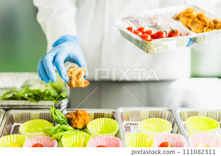 一名婦女在食品工廠製作午餐盒,不露面 一名婦女在食品工廠製作午餐盒,不露面 111082311