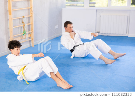 Man and boy teenager doing abdominal exercises 111082333