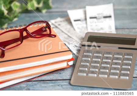 書桌上的收據、眼鏡和計算機 111083565