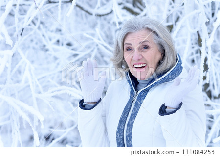 Happy old woman in a fur coat in the winter.  111084253