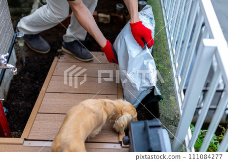 A man laying gravel in the garden, gardening 111084277
