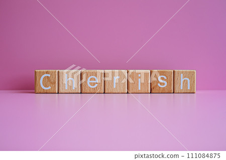 Wooden blocks form the text "Cherish" against a pink background. 111084875