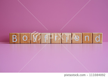 Wooden blocks form the text "Boyfriend" against a pink background. Wooden blocks form the text "Boyfriend" against a pink background. 111084892