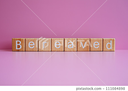 Wooden blocks form the text "Bereaved" against a pink background. Wooden blocks form the text "Bereaved" against a pink background. 111084898