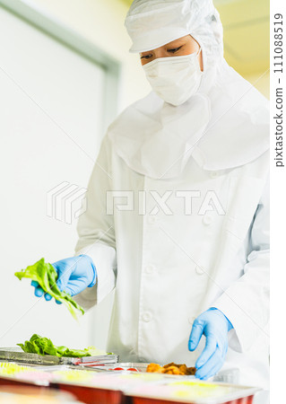 一位穿著乾淨西裝的年輕女子裝著配菜 111088519