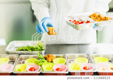 A woman at a food factory making lunch boxes, faceless A woman at a food factory making lunch boxes, faceless 111088525