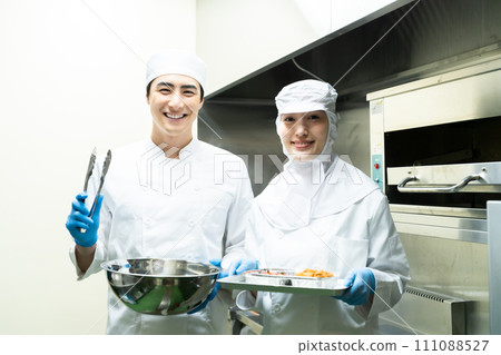 Young men and women working at a food factory 111088527