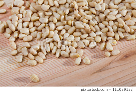 Pine nuts on a wooden surface.  Pine nuts on a wooden surface.  111089152
