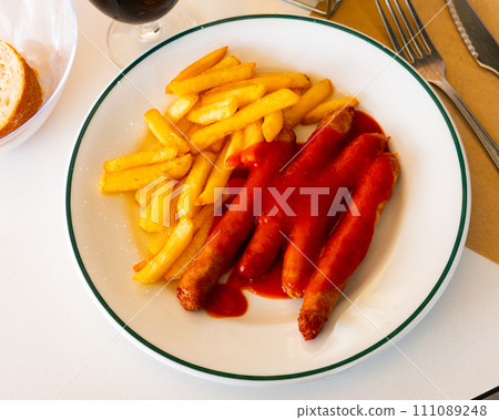 Sausages with potato slices in tomato sauce 111089248
