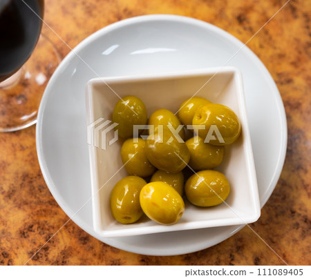 Bowl of green olives on wooden table Bowl of green olives on wooden table 111089405