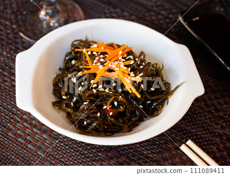 Japanese dish - seaweed salad with sesame seeds 111089411