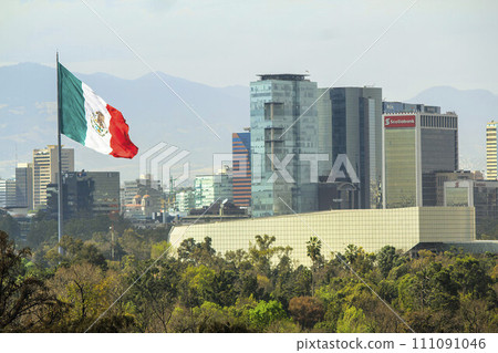 Mexico City, Mexico. Jan 14, 2024. The Mexican flag gracefully sways in the wind, set against the backdrop of modern corporate buildings and the iconic National Auditorium in downtown Mexico City. Mexico City, Mexico. Jan 14, 2024. The Mexican flag gracefully sways in the wind, set against the backdrop of modern corporate buildings and the iconic National Auditorium in downtown Mexico City. 111091046