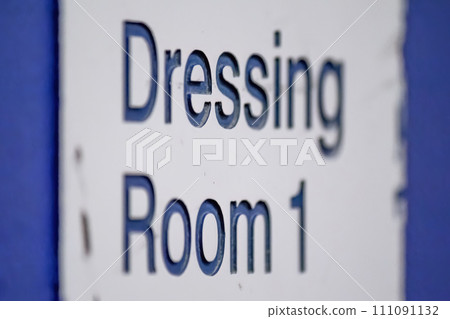 A dressing room sign on a wall at a sports facility. 111091132