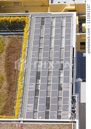 Several solar panels on the top of a building roof. Several solar panels on the top of a building roof. 111091287