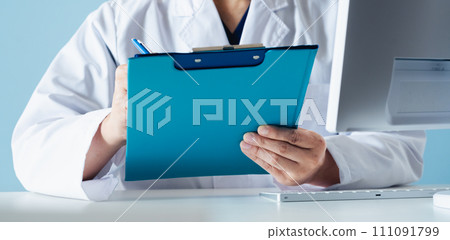 Hand of a male doctor holding a file 111091799