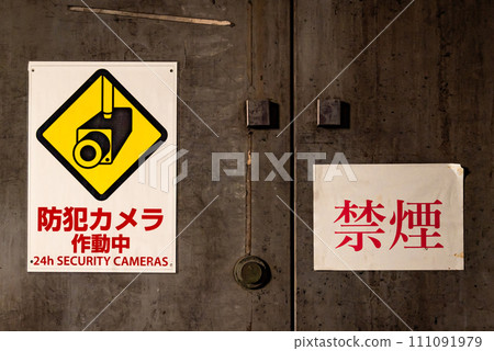 A scene with a security camera and a no-smoking sticker pasted on the door. A scene with a security camera and a no-smoking sticker pasted on the door. 111091979