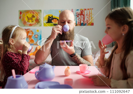 Having tea with two adorable daughters 111092647