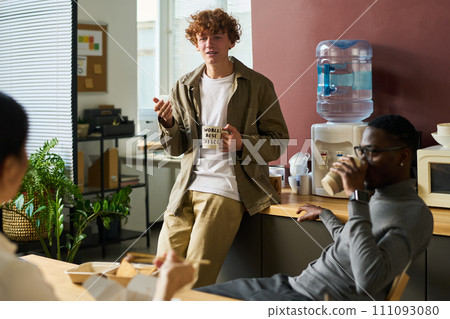 Guy with cup of coffee talking 111093080