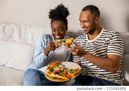 Man and woman eating pizza and having great time together at home Man and woman eating pizza and having great time together at home 111093808
