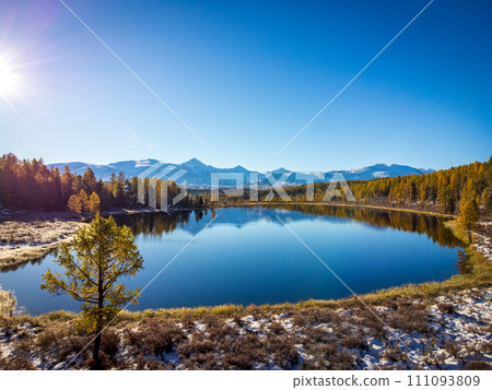 Breathtaking aerial view of a mountain lake surrounded by autumn forest Breathtaking aerial view of a mountain lake surrounded by autumn forest 111093809