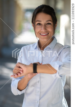 Excited woman looking at the watch and waiting for someone Excited woman looking at the watch and waiting for someone 111093929