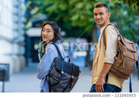International students walking near the campus and smiling. 111093953