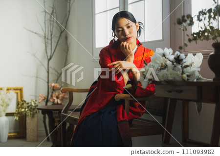 A woman wearing a vermilion furisode and hakama A woman wearing a vermilion furisode and hakama 111093982