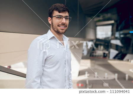 Contented young man looking confident and smiling Contented young man looking confident and smiling 111094041